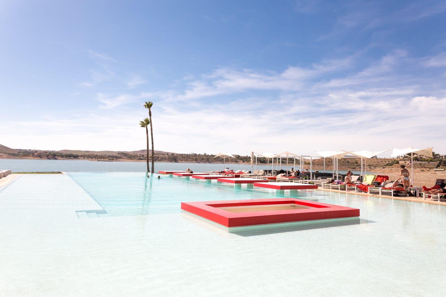 Piscine à débordement et transats face au lac