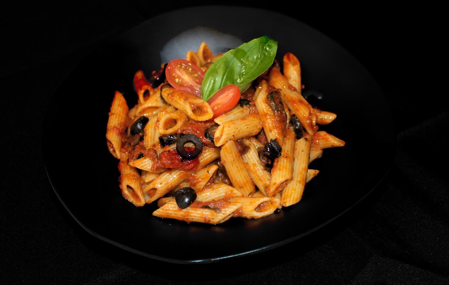 Assiette de pâtes tomate & olives, servie au bord du lac